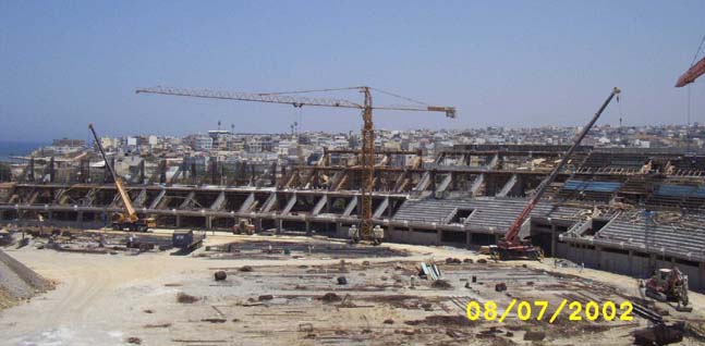 General view of the construction site from the west stand. OFI's "Theodore Vardinoyannis" Stadium can be seen in the distance (July 2002)